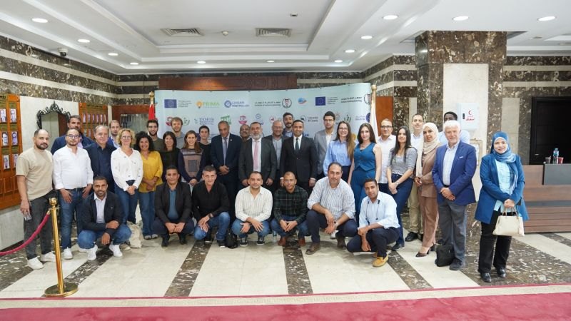 Group photo of the DIONYSUS consortium in front of the project banner at the INP in Cairo